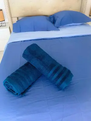 a blue blanket on a bed with a blue pillow at Les pieds dans l eau in Nice