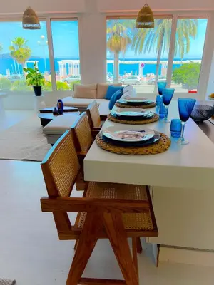 a dining room with a table with chairs and a couch at Les pieds dans l eau in Nice