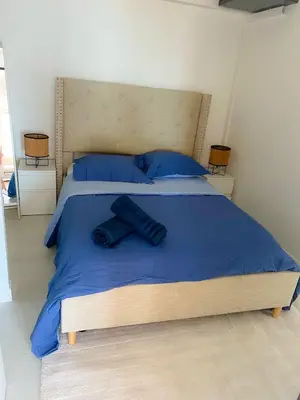 a large bed with blue sheets and pillows on it at Les pieds dans l eau in Nice