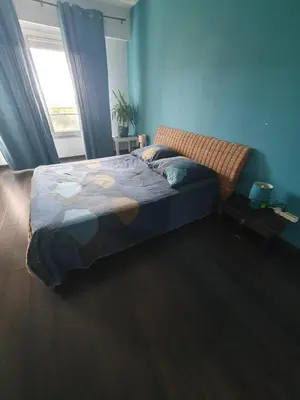 a bedroom with a bed with blue walls and a window at Large 2-room bright sea view near airport in Nice