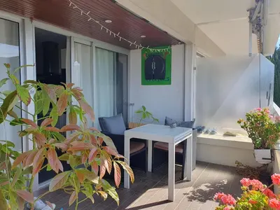a patio with a white table and a bath tub at Large 2-room bright sea view near airport in Nice