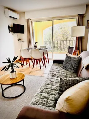a living room with a couch and a table at DOMAINE LOU BEL AZUR - Paisible in Saint-Laurent-du-Var