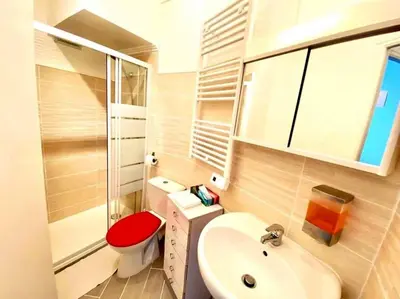 a bathroom with a red toilet and a sink at Joli studio cœur de Nice in Nice