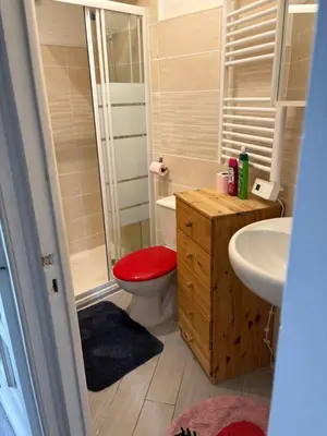 a bathroom with a toilet with a red seat at Joli studio cœur de Nice in Nice