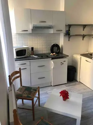 a kitchen with white cabinets and a table and a microwave at Joli studio cœur de Nice in Nice