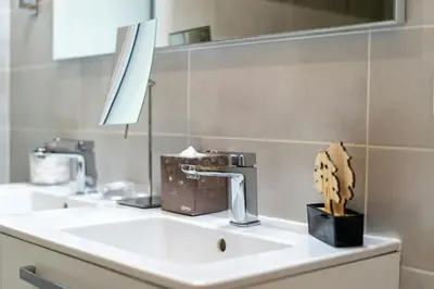 a bathroom sink with a faucet and a plant on it at Azur Panoramique – Calme Vue Mer proche Nice in Saint-Laurent-du-Var