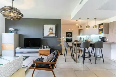 a kitchen and living room with a table and chairs at Azur Panoramique – Calme Vue Mer proche Nice in Saint-Laurent-du-Var