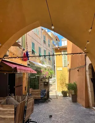 an archway in an alley with tables and chairs at Vue Mer Prestige in Villefranche-sur-Mer