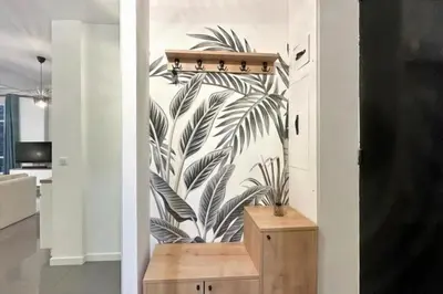 a hallway with a mural of palm leaves on a wall at Loft Carré d'or - Wifi, climatisation, 4 personnes in Nice