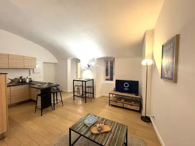 a living room with a table and a kitchen at Studio vieux nice coulee verte in Nice