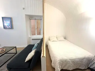 a bedroom with a bed and a couch in it at Studio vieux nice coulee verte in Nice