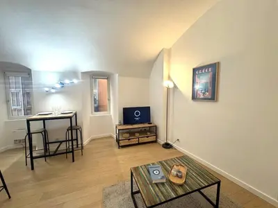 a living room with a table and a table sidx sidx sidx sidx at Studio vieux nice coulee verte in Nice