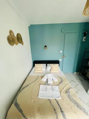 a bedroom with a large bed with blue walls at Sweethome Massena in Nice