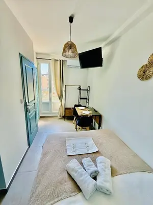 a bedroom with a bed with two towels on it at Sweethome Massena in Nice