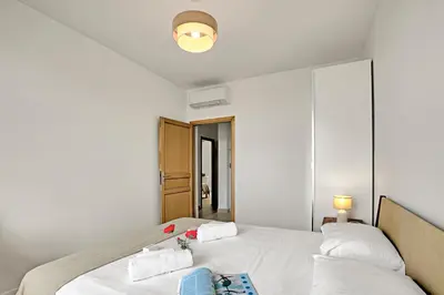 a bedroom with two beds with white sheets at Modern Apartment With City View - Happy Rentals in Nice