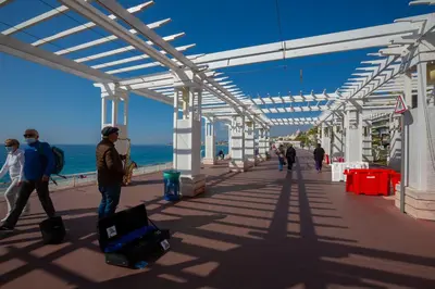 a group of people walking on the beach with luggage at Modern Apartment With City View - Happy Rentals in Nice