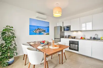 a kitchen and dining room with a wooden table and chairs at Modern Apartment With City View - Happy Rentals in Nice