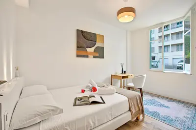 a white bedroom with a bed and a window at Modern Apartment With City View - Happy Rentals in Nice