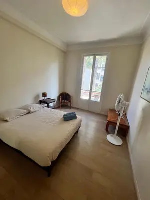 a bedroom with a bed and a desk and a fan at Charmant appartement avec terrasse en plein cœur de Nice à deux pas de la mer ! in Nice