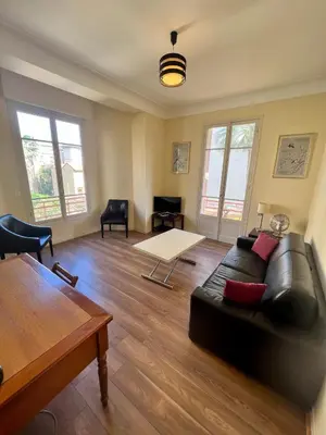 a living room with a couch and a table at Charmant appartement avec terrasse en plein cœur de Nice à deux pas de la mer ! in Nice