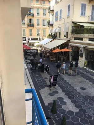 a group of people walking down a street with buildings at New central nice sea down town in Nice