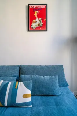 a blue couch with a poster on the wall at Loft hyper-centre de Nice in Nice