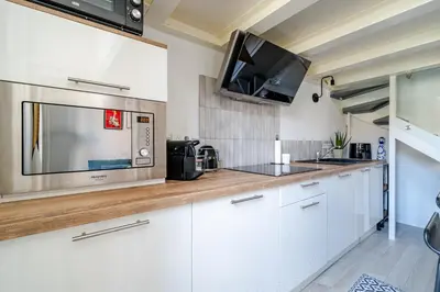 a kitchen with white cabinets and a microwave at Loft hyper-centre de Nice in Nice