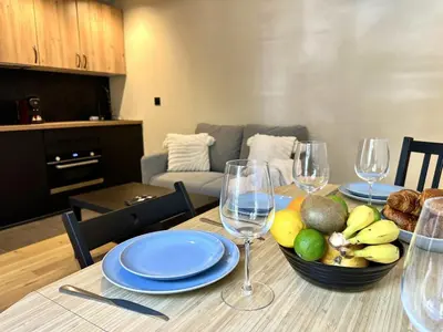 a dining room table with a bowl of fruit and wine glasses at Côté Mer - Élégant 3 pièces, Wifi et climatisation in Nice