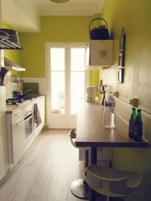 a kitchen with green walls and a wooden counter top at Joli 2 pièces à 2 min de la plage in Nice