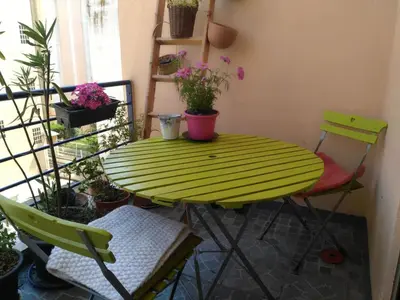 a green table and chairs in a room with plants at Joli 2 pièces à 2 min de la plage in Nice