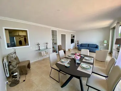 a dining room and living room with a table and chairs at NICE 2P Panoramic Sea View Wi-Fi AC in Nice
