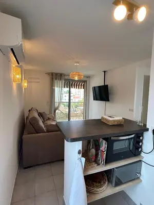 a living room with a table and a couch at Appartement cosy à 200 m de la mer in Cagnes-sur-Mer