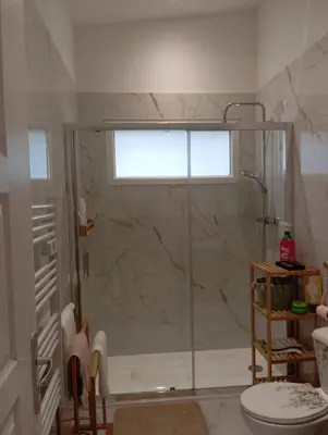 a bathroom with a shower and a toilet and a window at maison individuelle in Tourrette-Levens