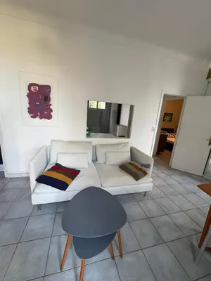 a living room with a white couch and a table at Petite Villa Eze Bord de Mer in Èze