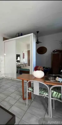 a living room with a wooden table and a mirror at Petite Villa Eze Bord de Mer in Èze