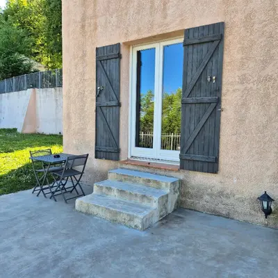 a patio with two doors and a table and a table at Saint-Jeannet Studio apartment near Nice in Saint-Jeannet