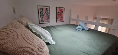 a bedroom with a bed with a green comforter at Sunset Villa atypical with air conditioning in Nice