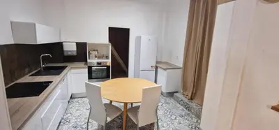 a small kitchen with a wooden table and chairs at Sunset Villa atypical with air conditioning in Nice