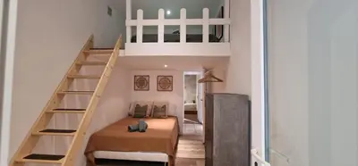 a small room with a bed under a staircase at Sunset Villa atypical with air conditioning in Nice