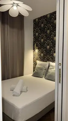 a bedroom with a white bed with a ceiling fan at MOON 25 in Nice