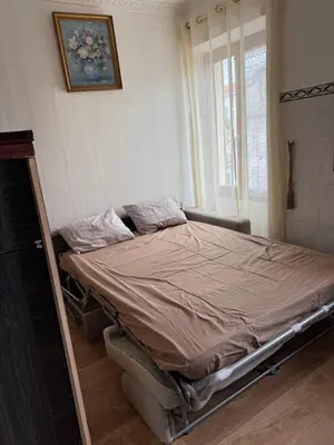 an empty bed in a room with a window at Daghsen in Nice