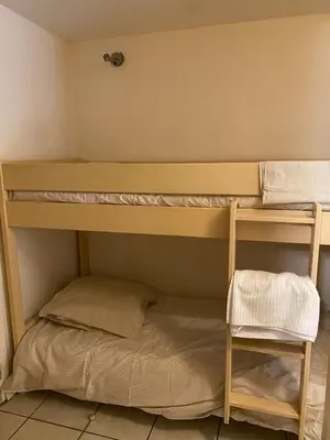 a bunk bed in a room with a ladder and a shelf at Studio 50M de la mer in Saint-Laurent-du-Var