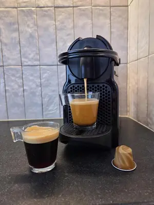 a coffee maker is making a cup of coffee at 