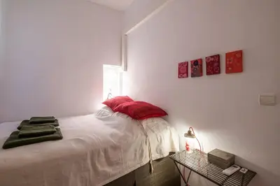 a bedroom with a bed with red pillows on it at 