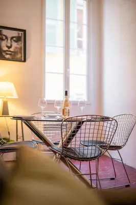 a glass table with two chairs and a bottle of wine at 