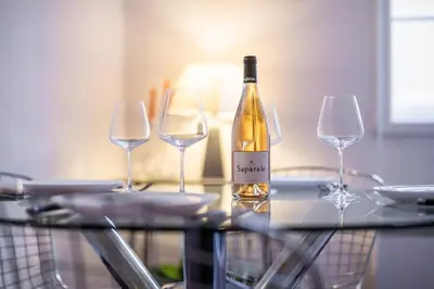 a bottle of wine sitting on a table with two wine glasses at 