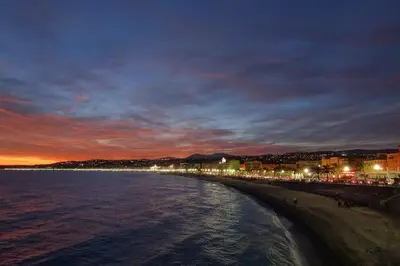 a view of a beach at night with lights at 