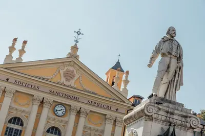 a statue in front of a building with a clock tower at 