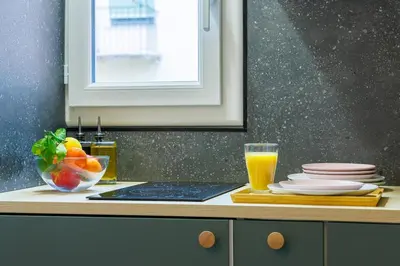 a kitchen counter with a bowl of fruit and a glass of orange juice at Charmant studio refait à neuf quartier du port in Nice