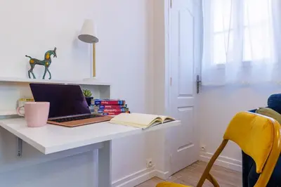 a desk with a laptop and a book on it at Charmant studio refait à neuf quartier du port in Nice